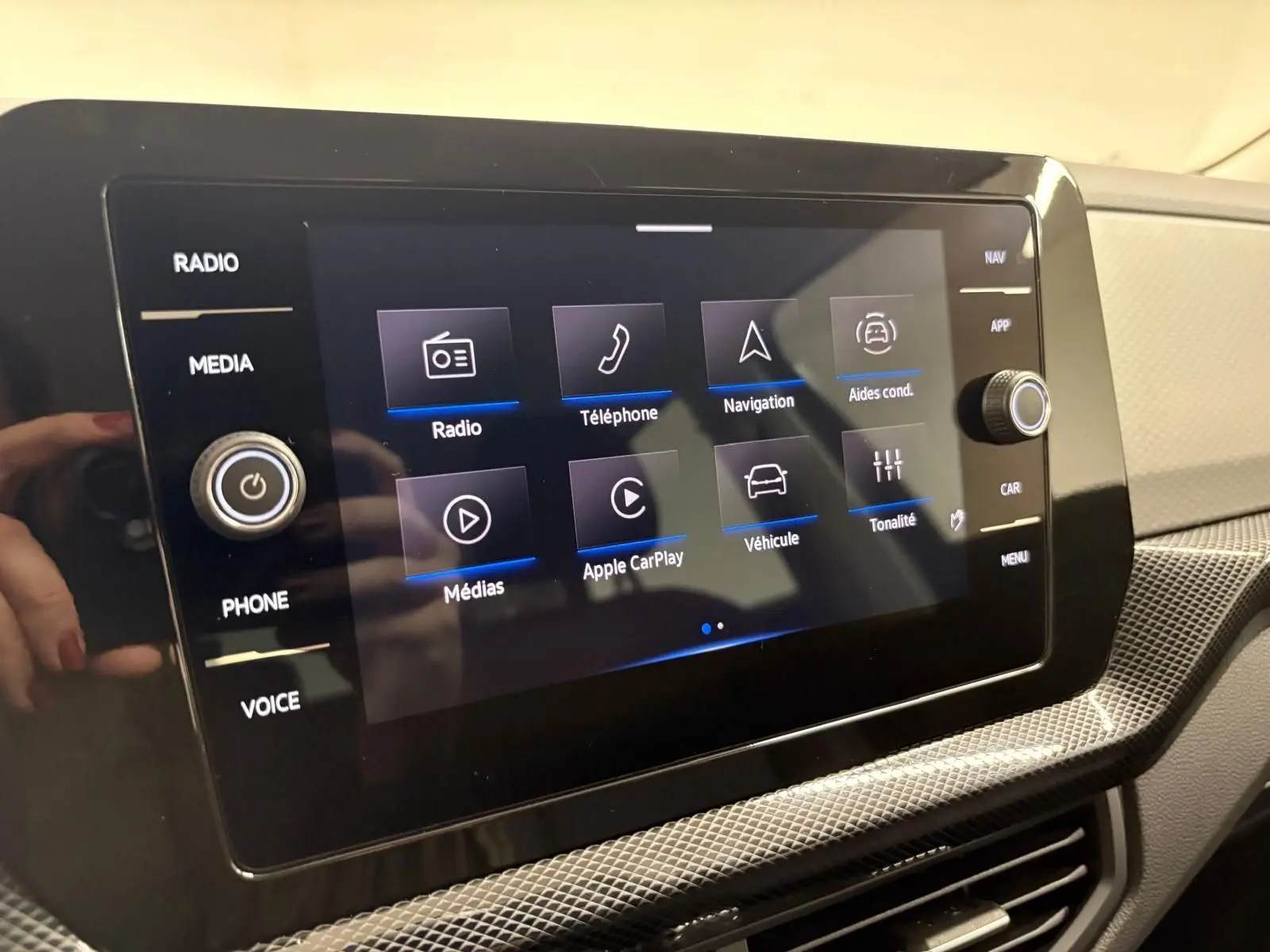 Écran tactile central du Volkswagen T-cross 2024 affichant les options radio, navigation et Apple CarPlay.
