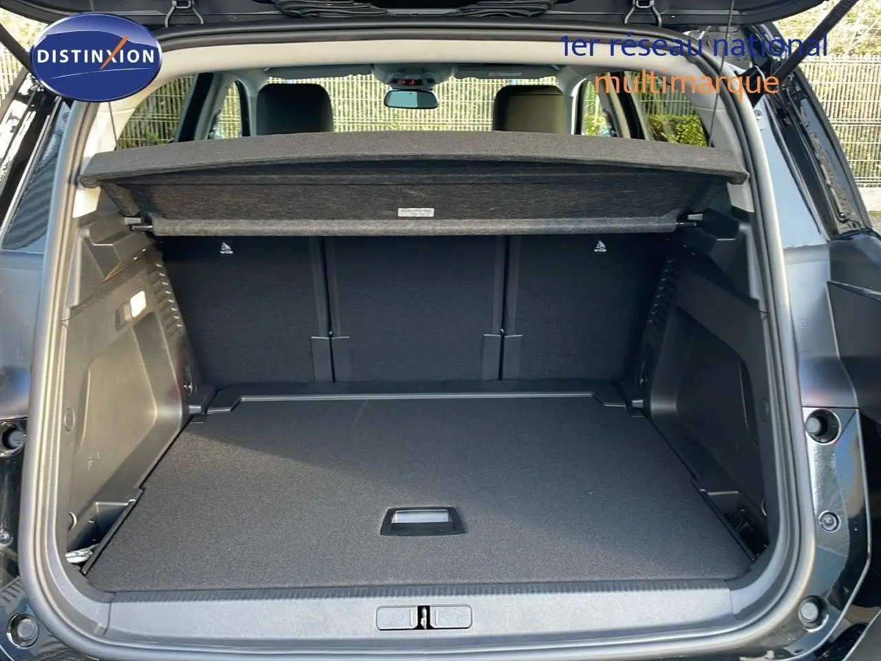 Coffre ouvert vu de l'arrière d'un Citroën C5 Aircross noir Perla Metal, avec cache-bagages déployé.