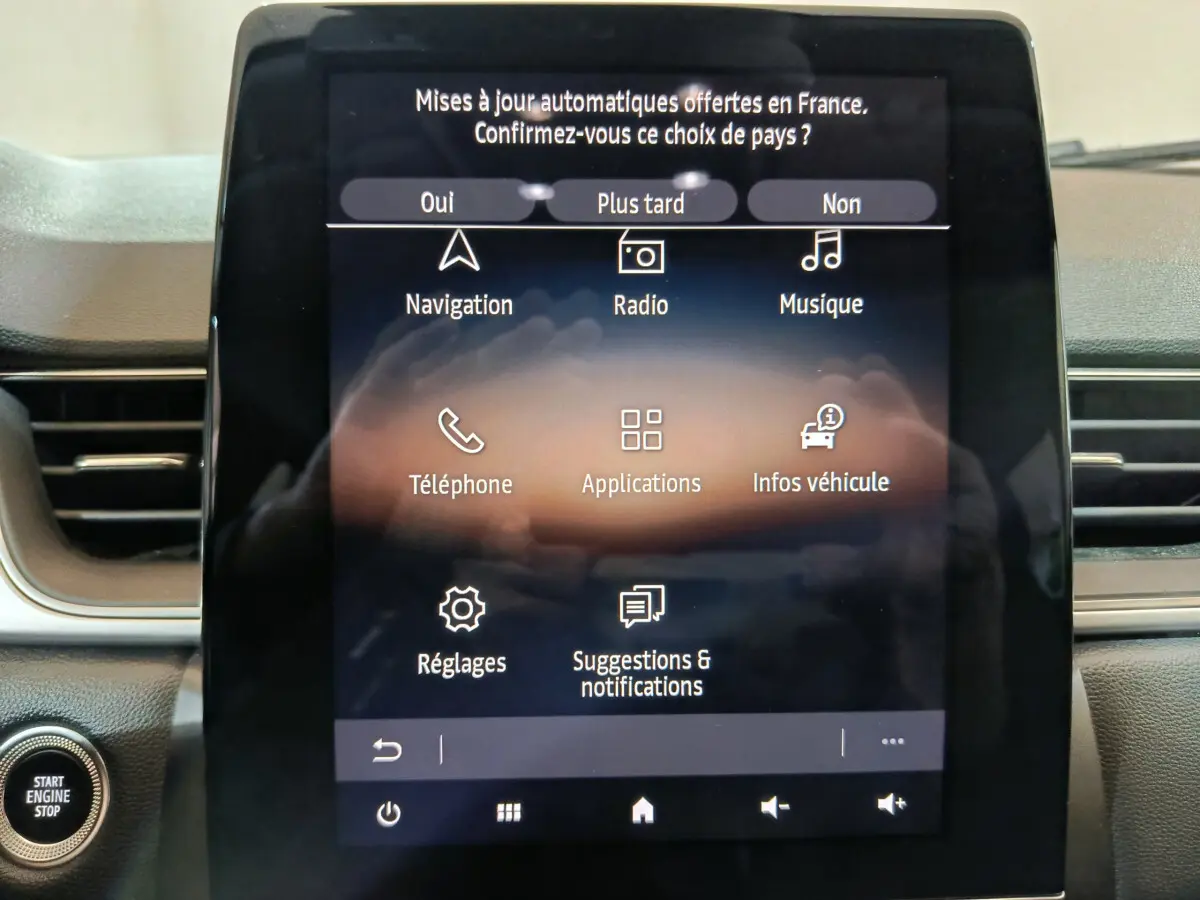 Écran tactile central de la Renault Captur rouge 2024 affichant le menu principal avec options de navigation et radio.