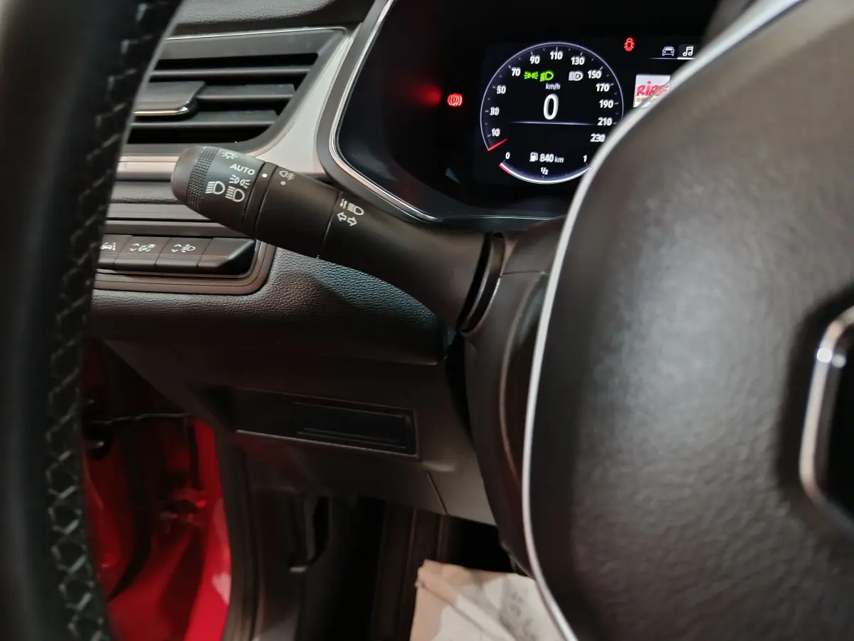 Vue intérieure rapprochée du combiné d'instruments et du commodo gauche du Renault Captur rouge Techno TCe 90 2024.