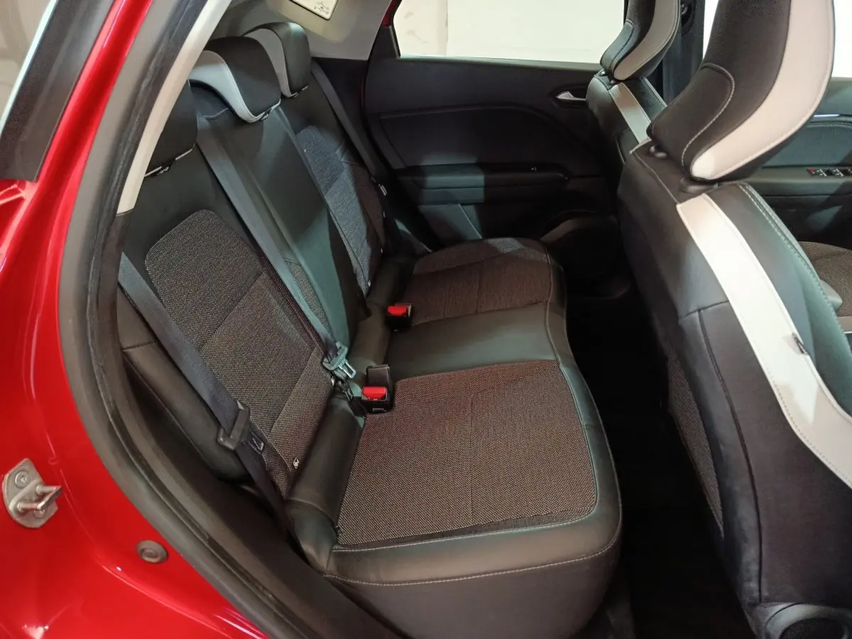 Vue côté gauche des sièges arrière en tissu et cuir du Renault Captur Techno TCe 90 rouge 2024, avec ceinture de sécurité visible.