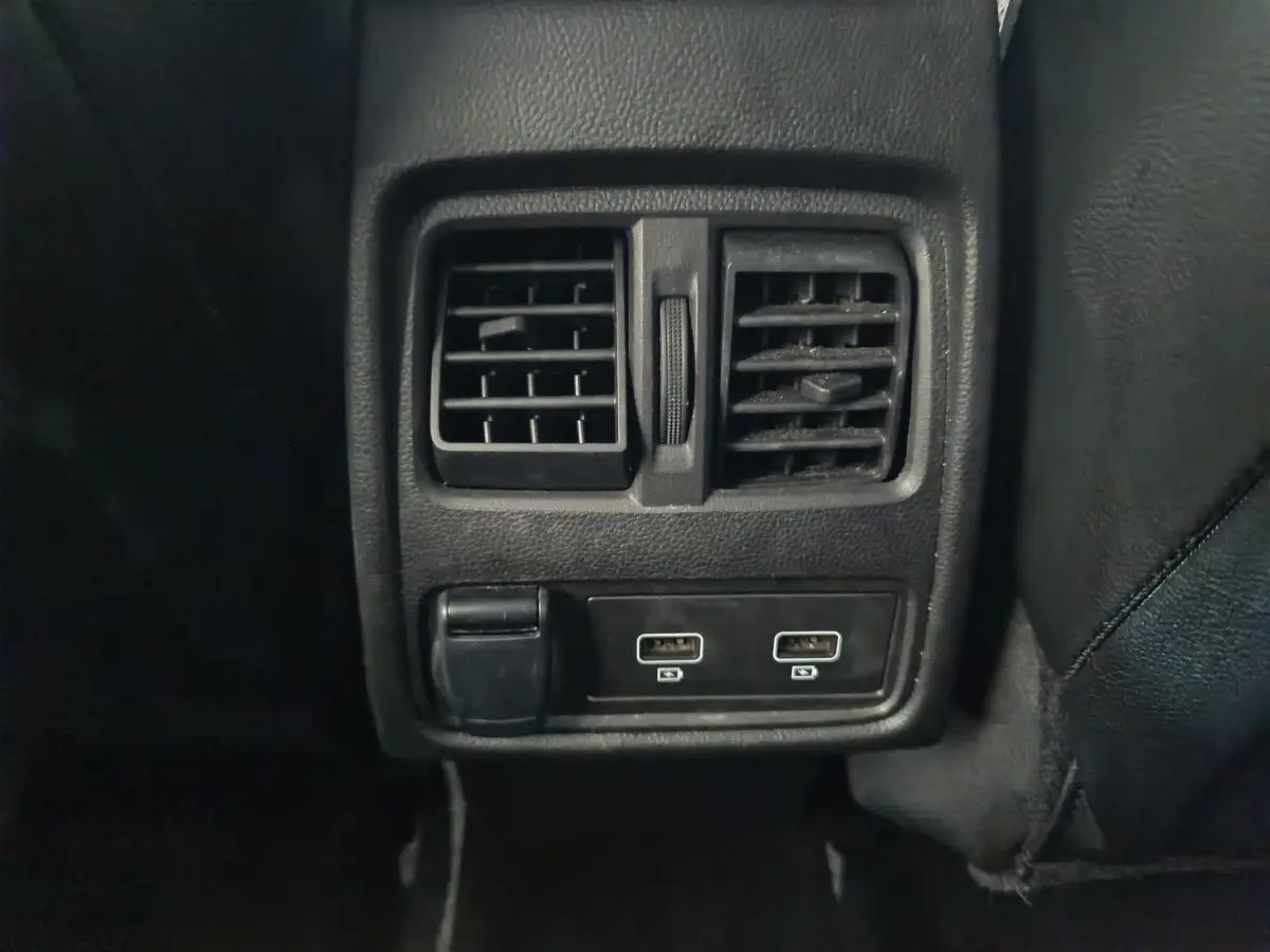 Gros plan sur la console arrière noire du Renault Captur 2024 avec bouches d’aération et deux ports USB.