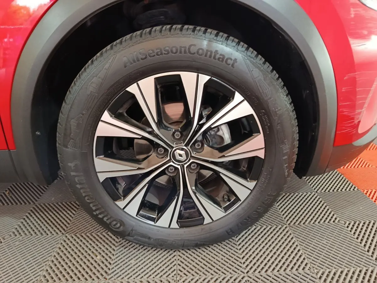 Gros plan sur la roue avant gauche du Renault Captur rouge 2024 avec jante alliage bicolore et pneu Continental.