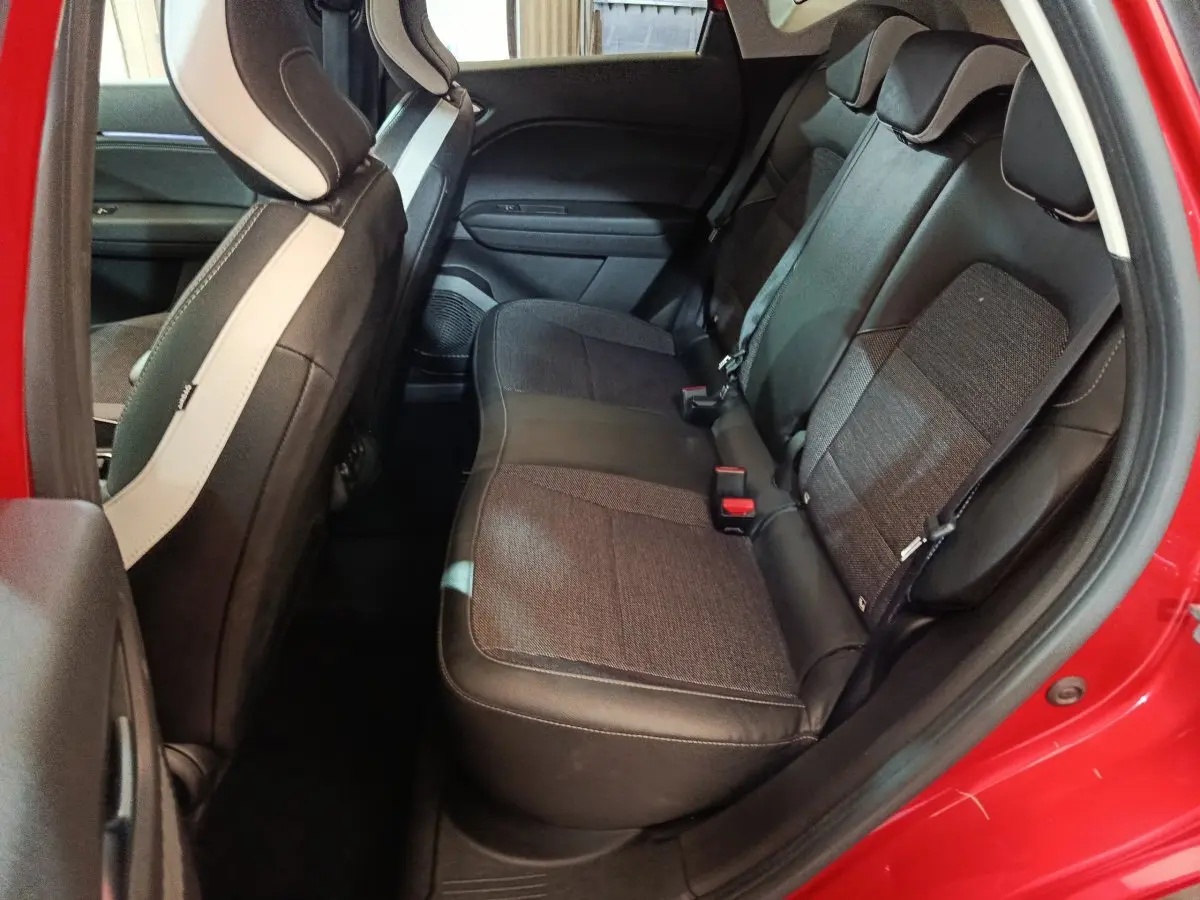 Vue intérieure côté droit sur la banquette arrière noire et grise du Renault Captur rouge 2024, porte ouverte.