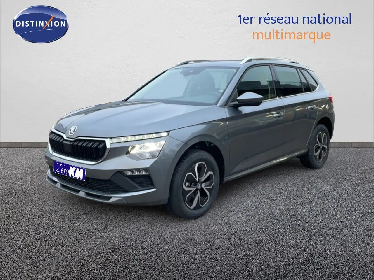 Vue 3/4 avant d'un Skoda Kamiq gris graphite métallisé avec jantes alliage et calandre noire distinctive.