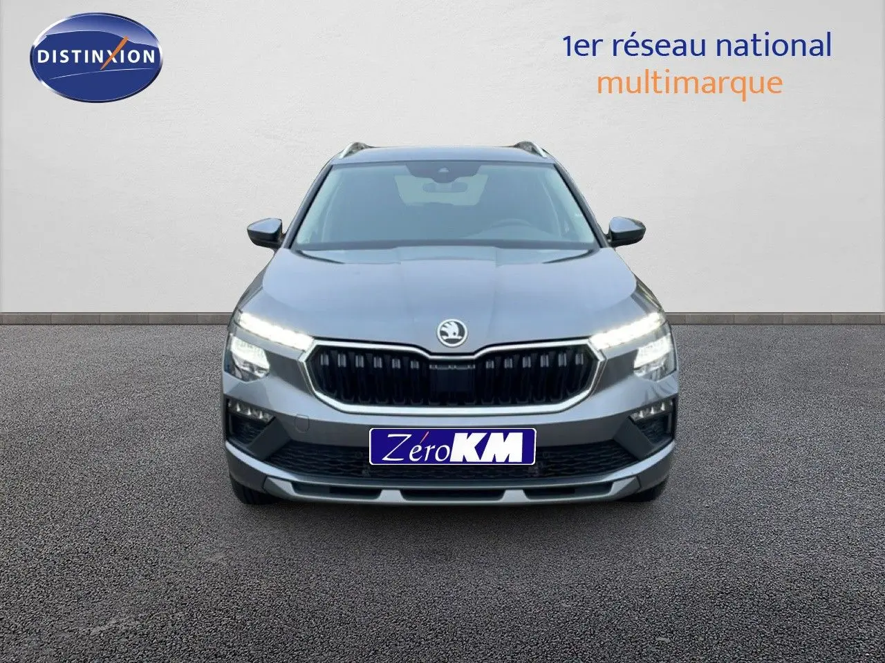 Vue frontale d'un Skoda Kamiq gris graphite métal 2025 avec calandre noire et phares LED allumés.