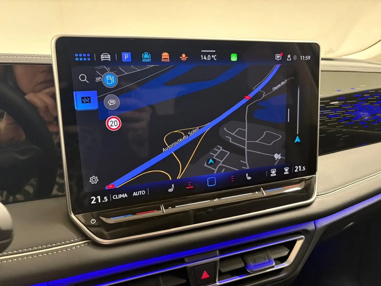 Écran tactile central du Volkswagen Tiguan 2025 avec navigation, ambiance lumineuse bleue et tableau de bord gris.