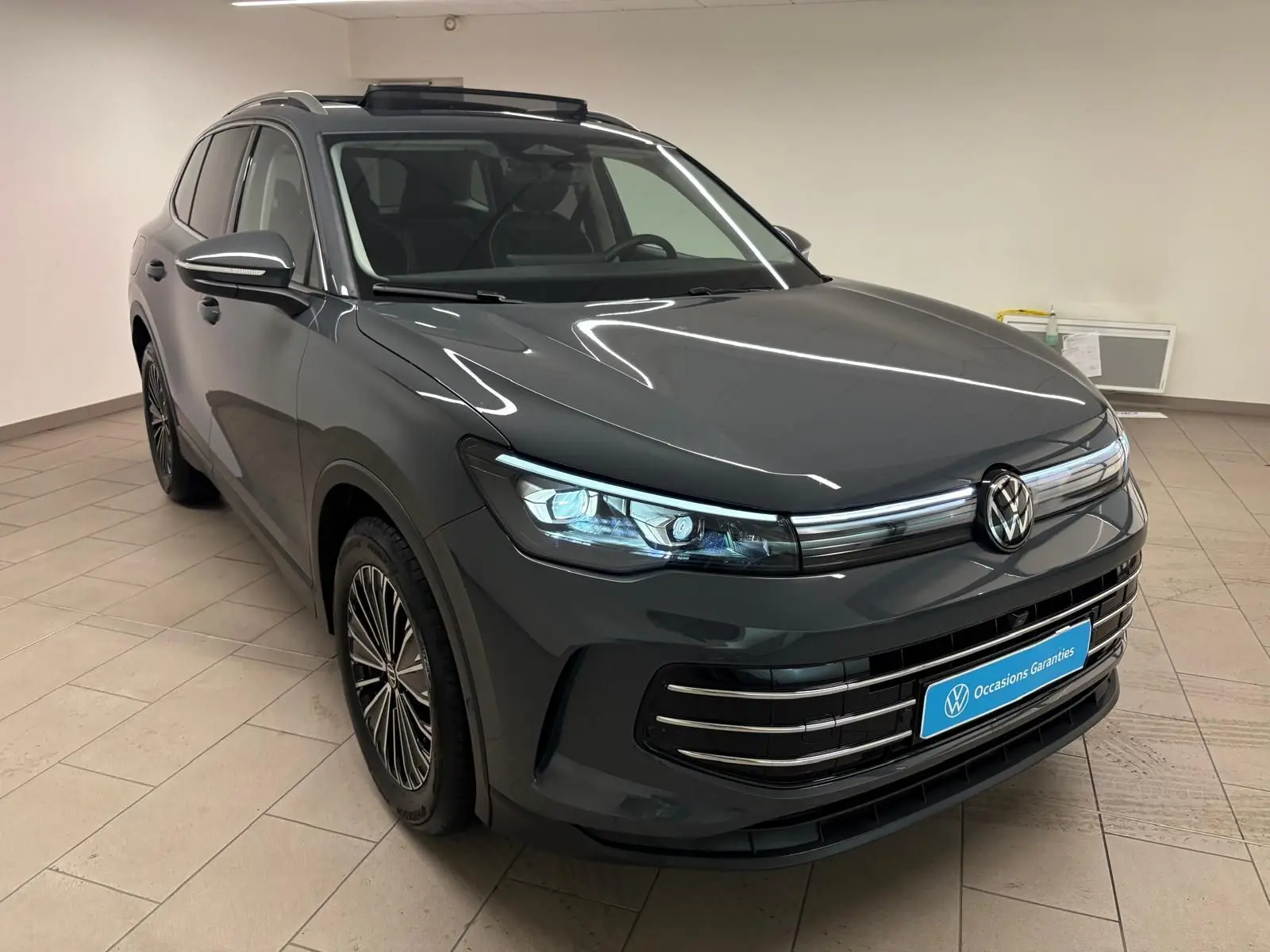 Volkswagen Tiguan 2.0 TDI 150 DSG7 Elegance gris dauphin, vue 3/4 avant droit en intérieur showroom.