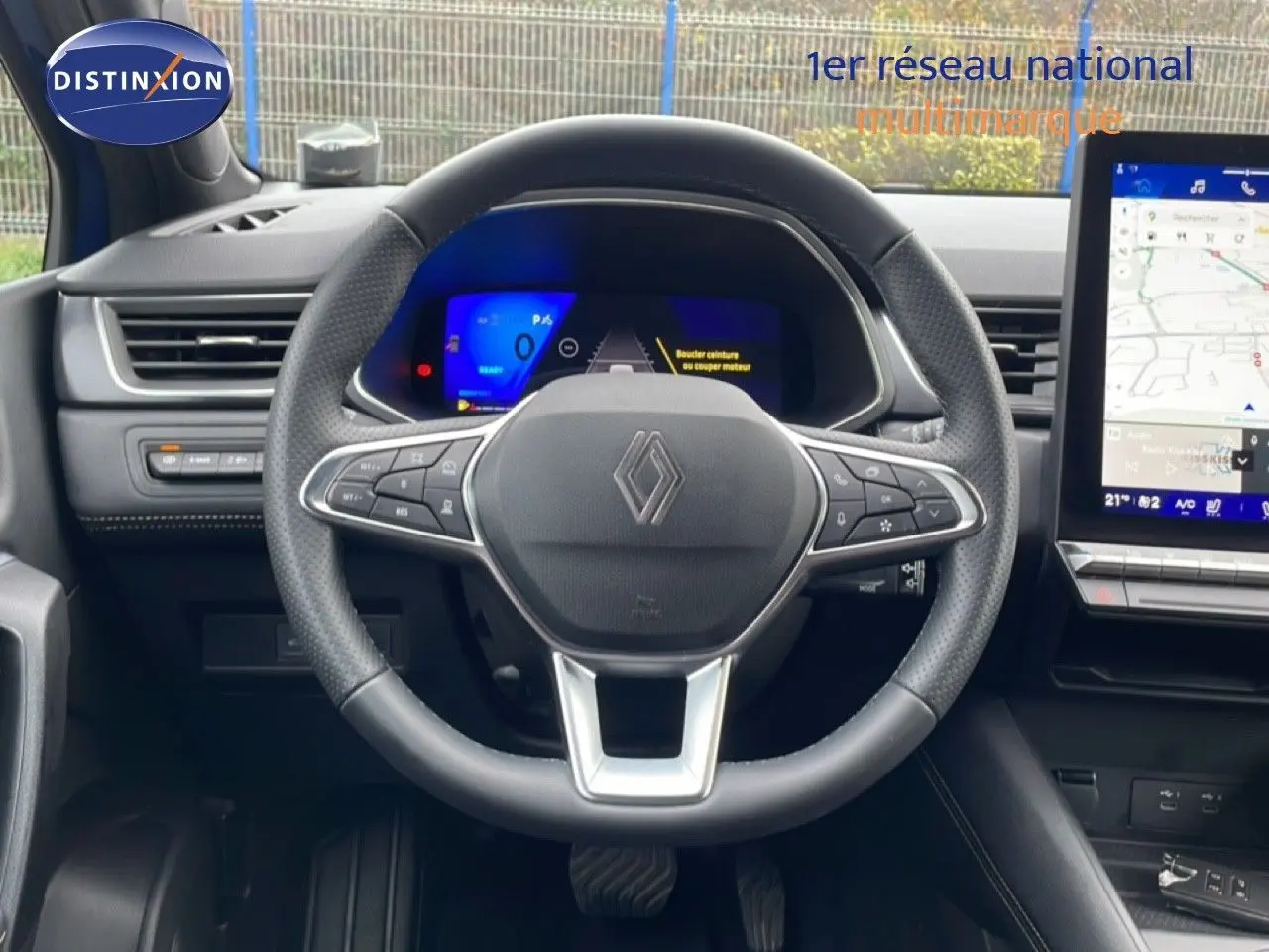 Vue intérieure centrée sur le volant Renault Symbioz 2025, avec tableau de bord numérique et écran tactile de navigation.