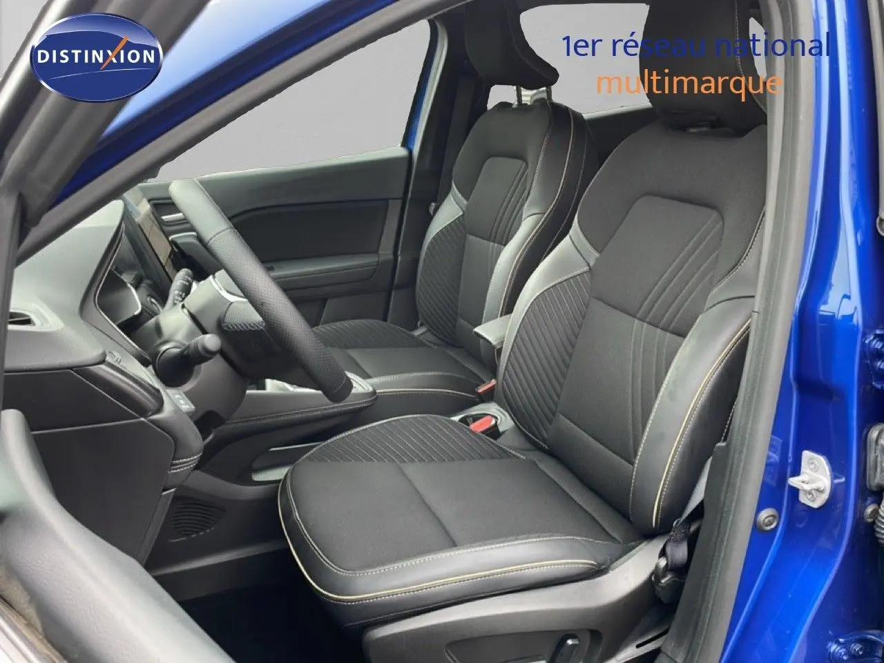 Vue intérieure côté gauche de la Renault Symbioz 2025 bleu iron metal, sièges tissu noir avec surpiqûres contrastées.