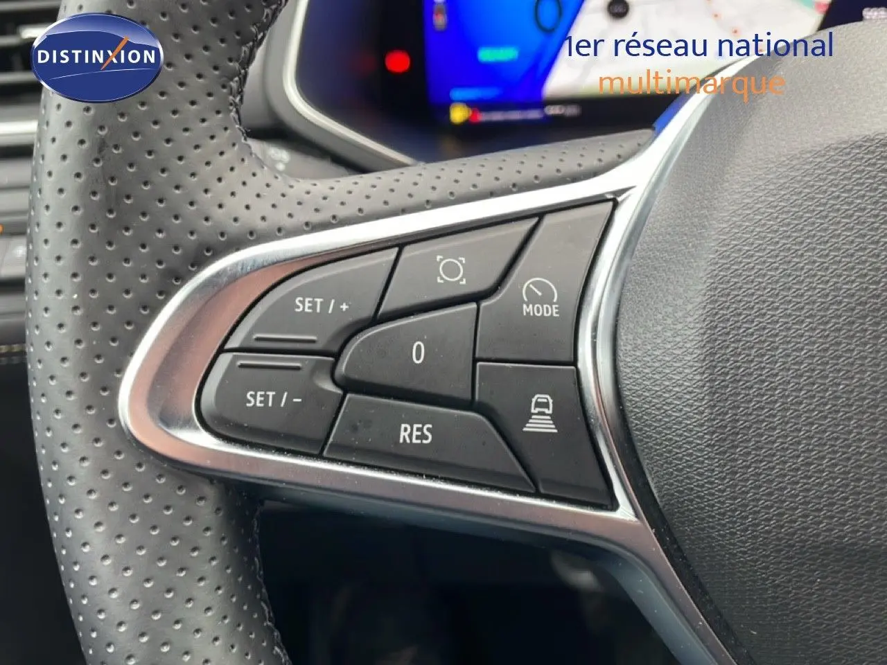 Gros plan sur les commandes au volant en cuir perforé noir du Renault Symbioz 2025, avec affichage numérique flou en arrière-plan.