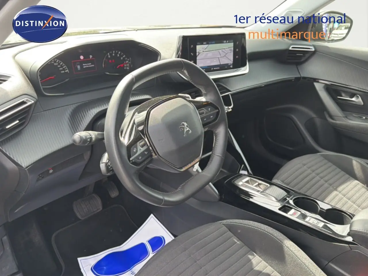 Vue intérieure côté conducteur du Peugeot 2008 2022, tableau de bord et volant avec écran tactile central en évidence.