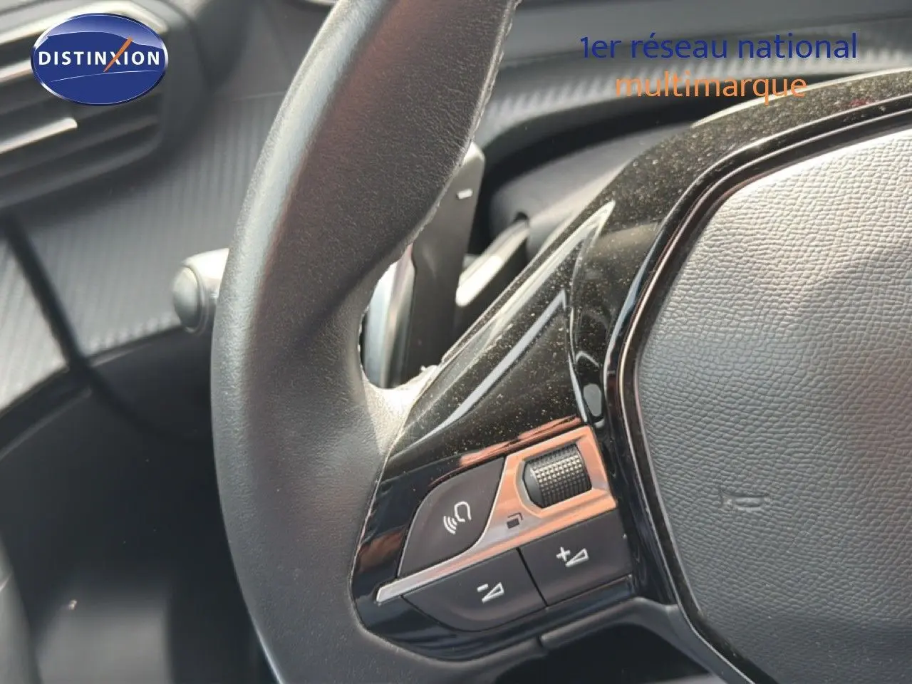Gros plan sur le volant noir du Peugeot 2008 2022, mettant en valeur les commandes audio intégrées.