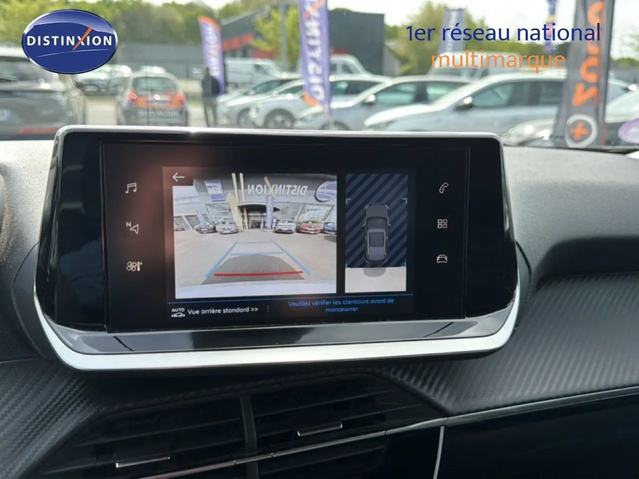 Écran tactile central affichant la caméra de recul et l'aide au stationnement dans un Peugeot 2008 noir perle métal.