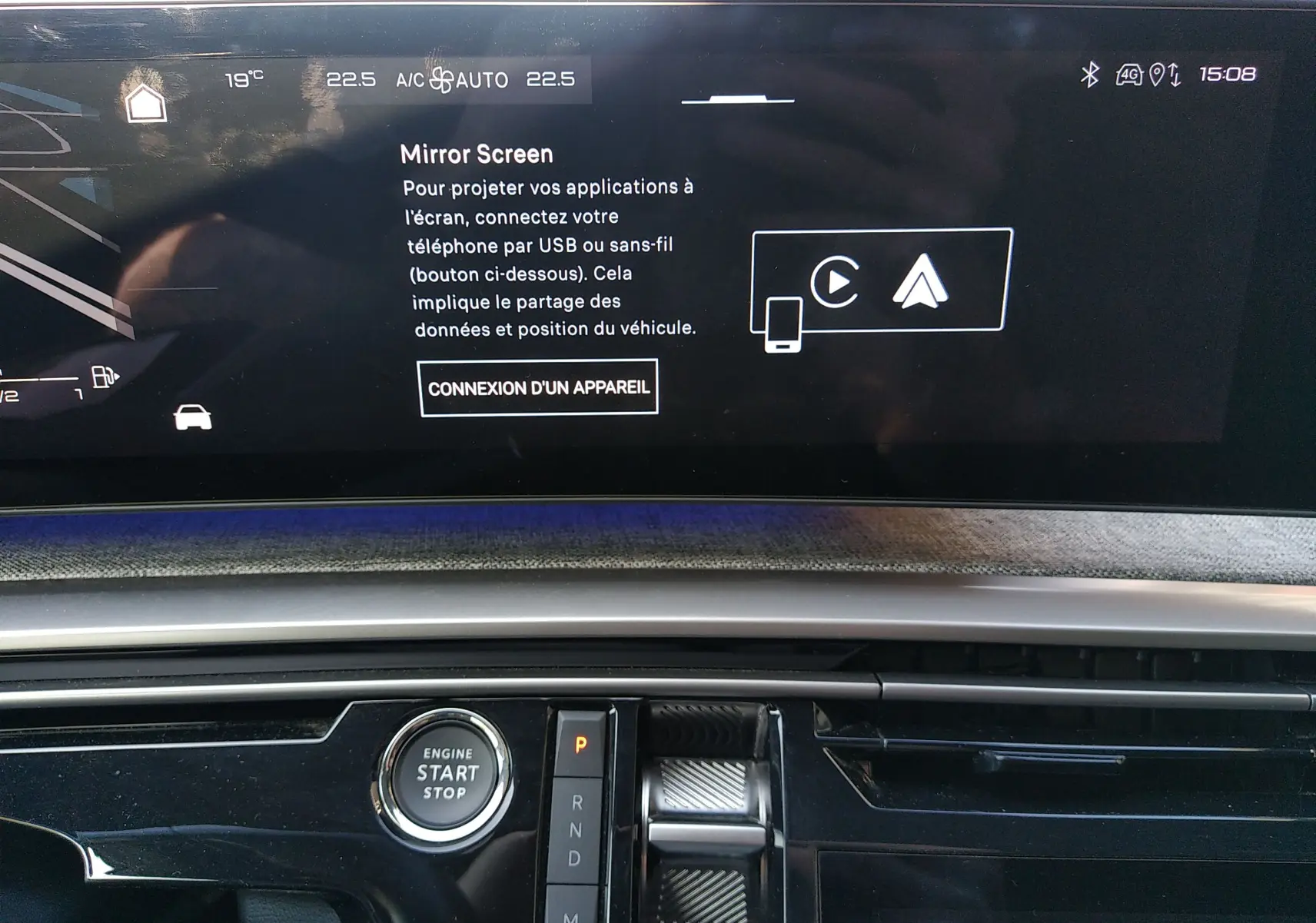 Vue rapprochée de l’écran central et console du Peugeot 3008 Hybrid gris titane 2024, avec bouton start/stop et levier de vitesses.