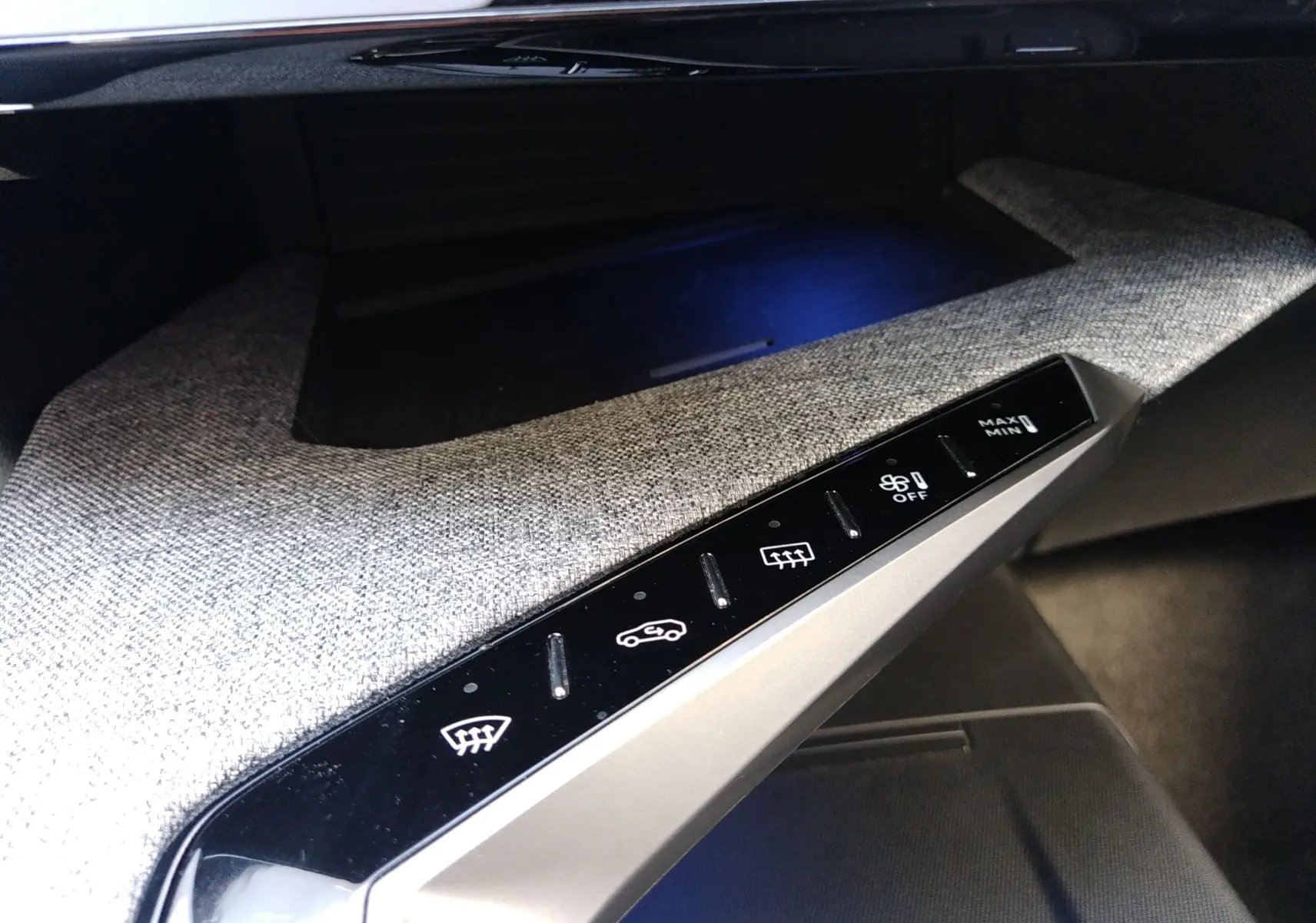 Détail de la console intérieure du Peugeot 3008 Hybrid 136 Allure 2024, avec commandes tactiles et habillage gris clair.