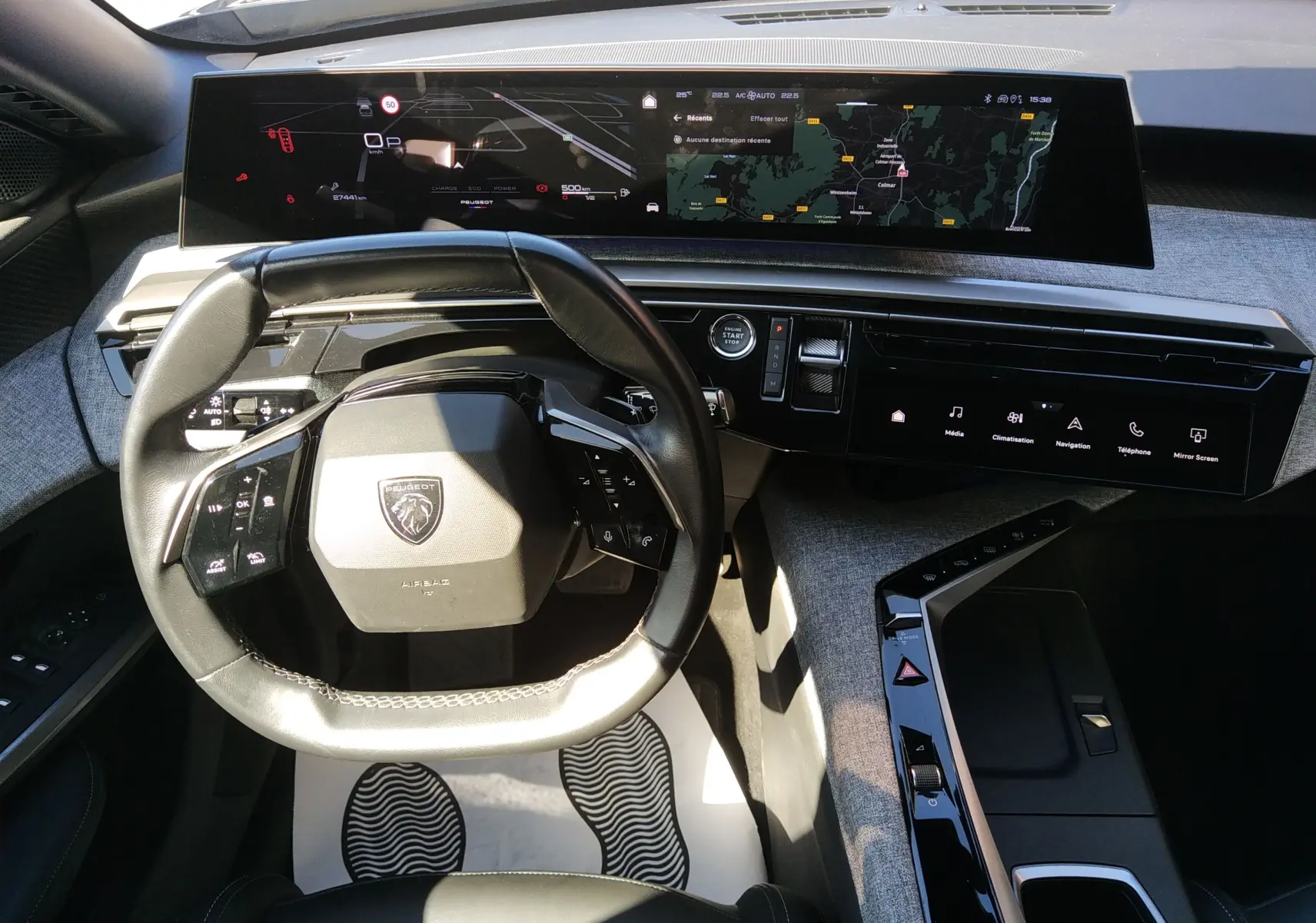 Vue intérieure du poste de conduite du Peugeot 3008 Nouveau Hybrid 136 Allure 2024, avec tableau de bord numérique panoramique et volant compact noir.