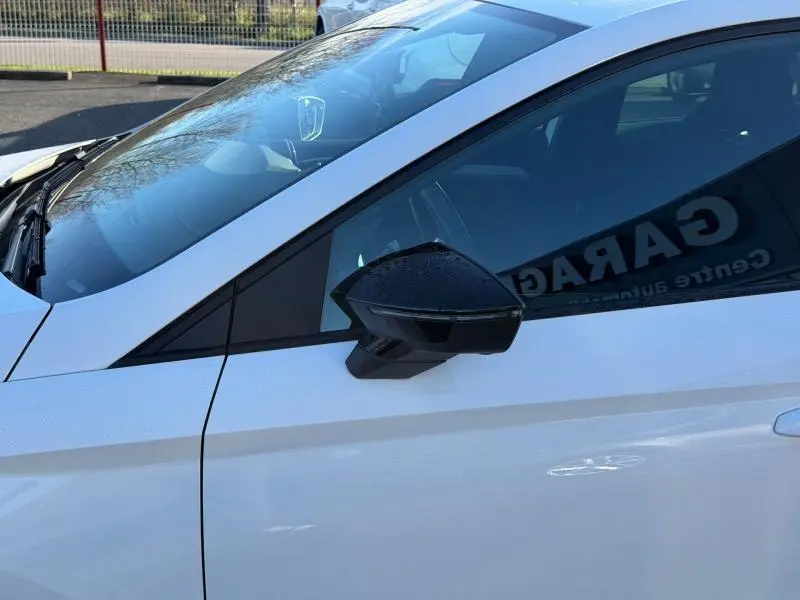 Gros plan sur le rétroviseur noir côté conducteur d'une SEAT IBIZA 2025 blanc Nevada métallisé, vue latérale droite.