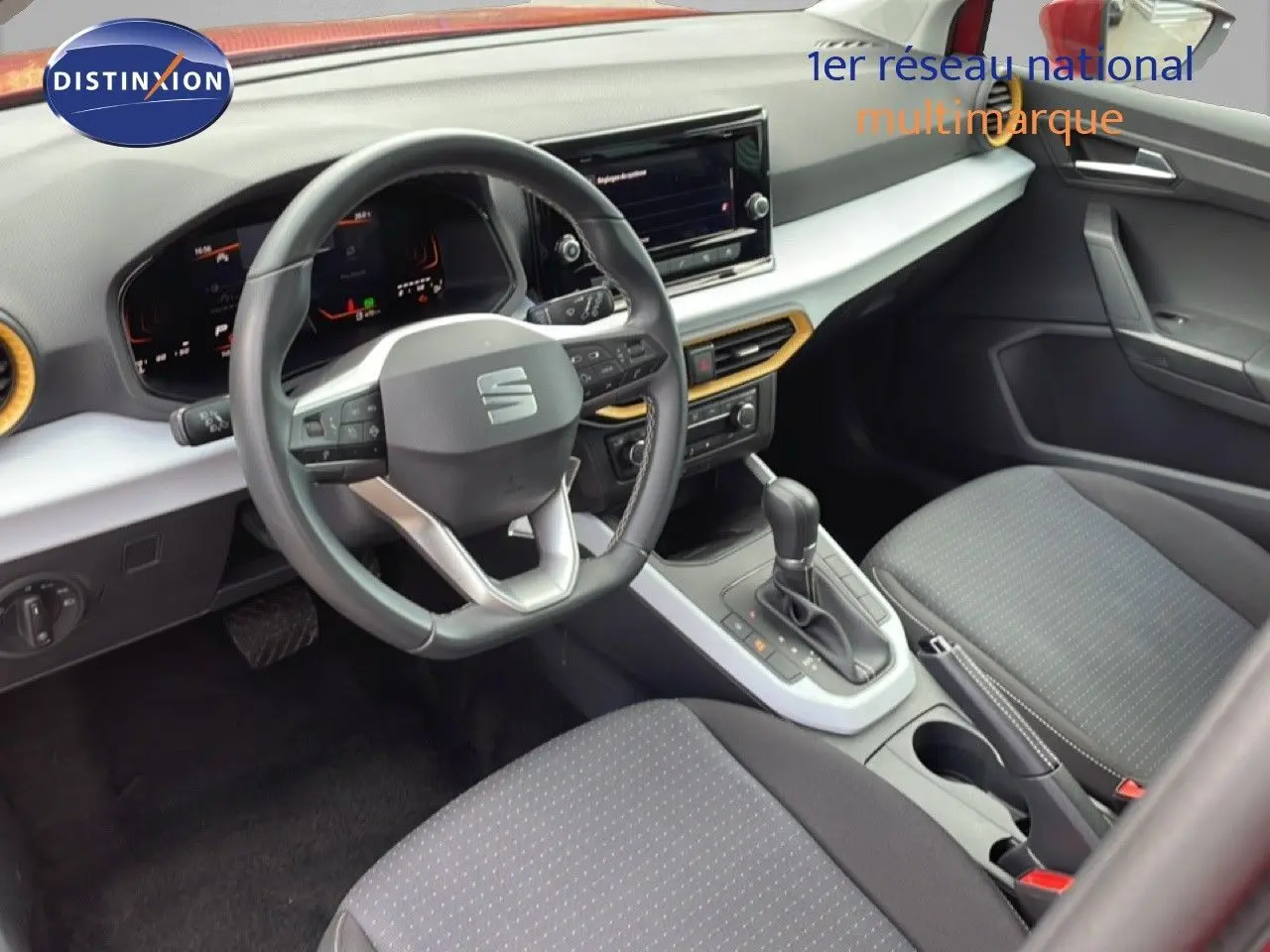 Vue intérieure avant droite du SEAT Arona 2025 avec volant cuir multifonction et sellerie tissu gris.