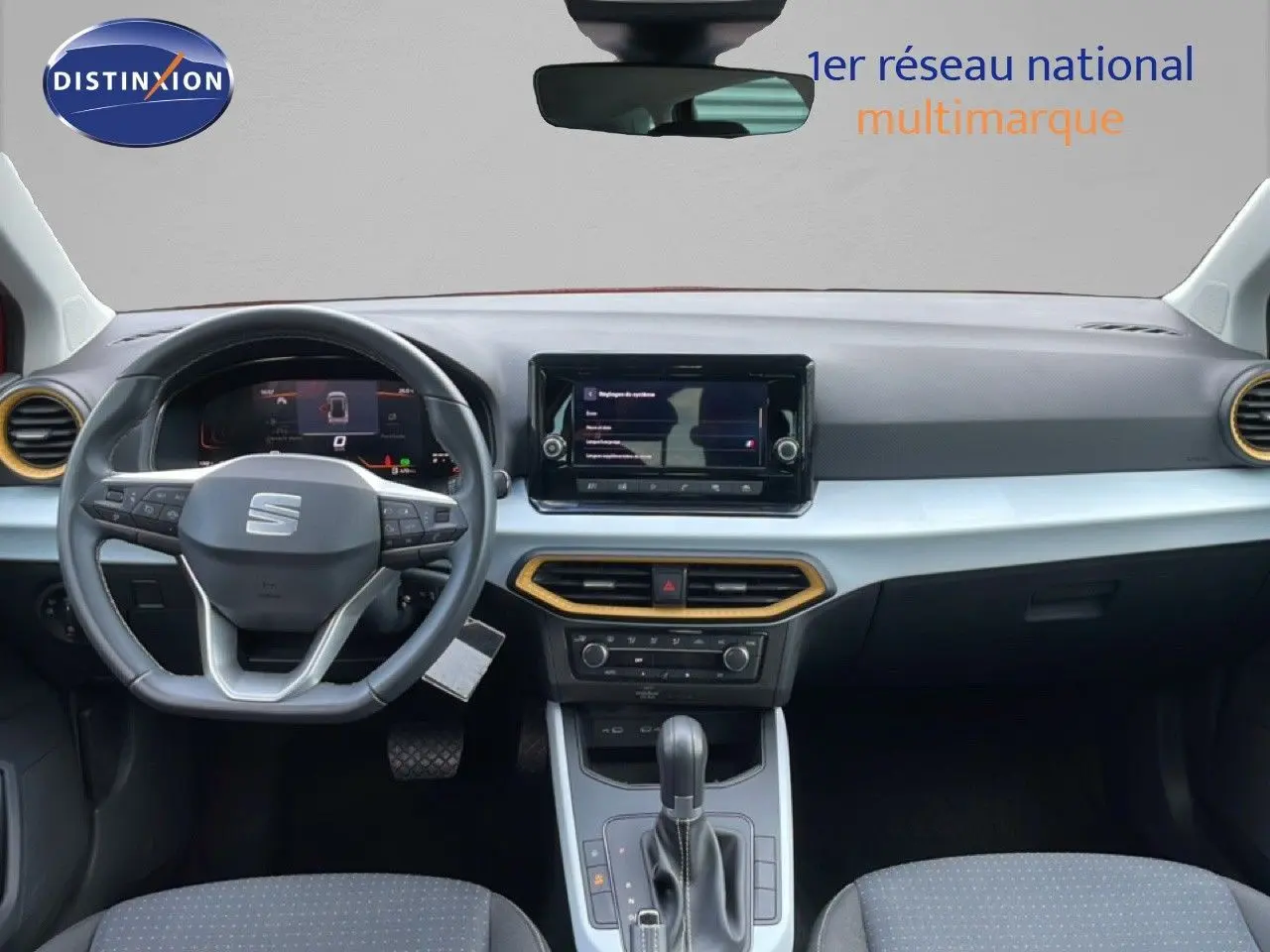 Vue intérieure du tableau de bord et volant de la SEAT Arona 2025, avec détails noirs et inserts dorés autour des aérateurs.