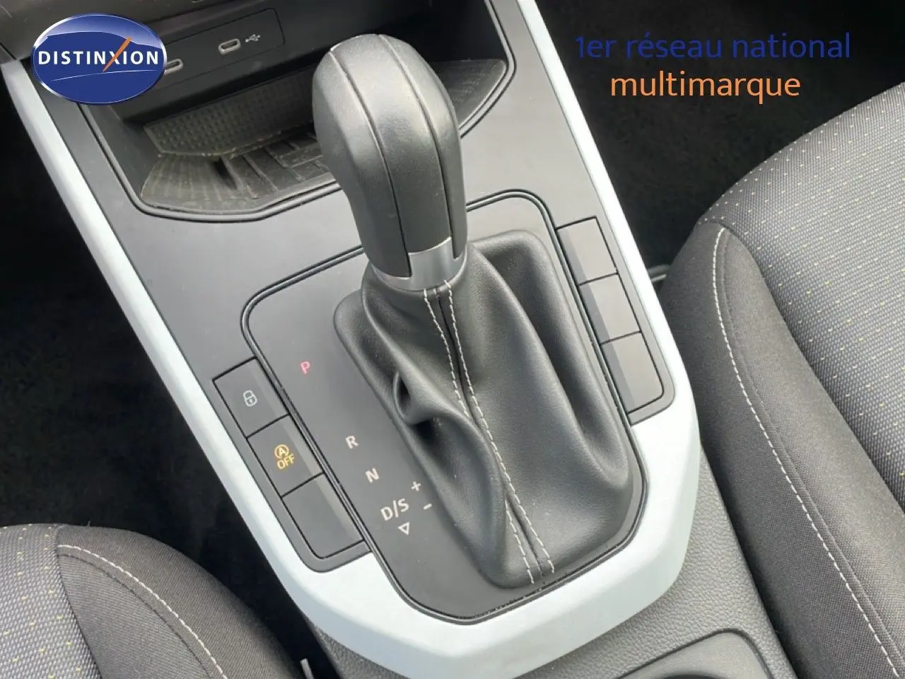 Gros plan sur le levier de vitesses automatique noir et la console centrale grise du SEAT Arona 2025, intérieur tissu gris.