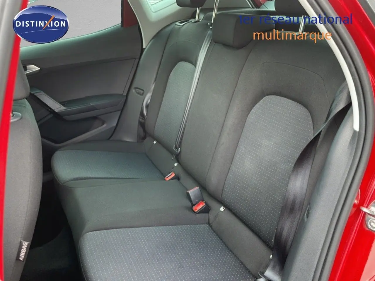 Vue intérieure côté droit des sièges arrière noirs d’un SEAT Arona rouge Désir Métal avec toit noir, porte arrière ouverte.