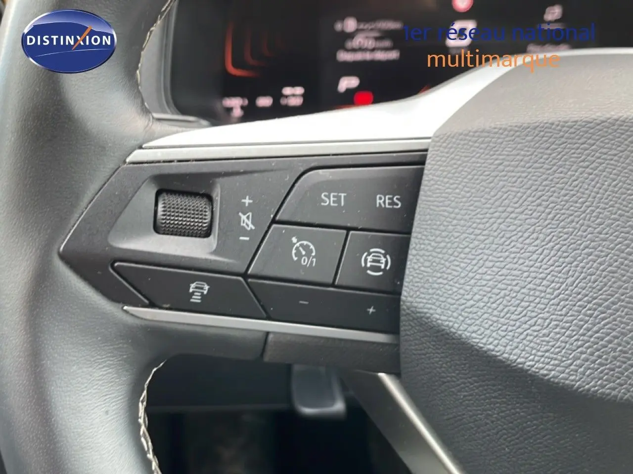 Gros plan sur les commandes au volant à gauche du SEAT Arona 2025, volant cuir noir avec boutons multifonctions.