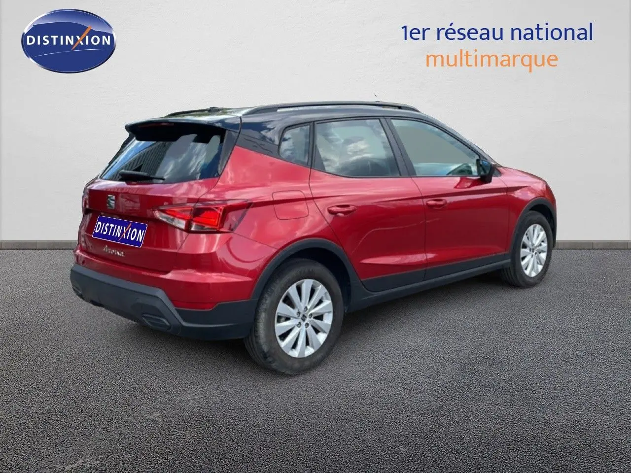 Vue 3/4 arrière droite d'un SEAT Arona rouge désir métal avec toit noir, roues argentées et détails noirs.