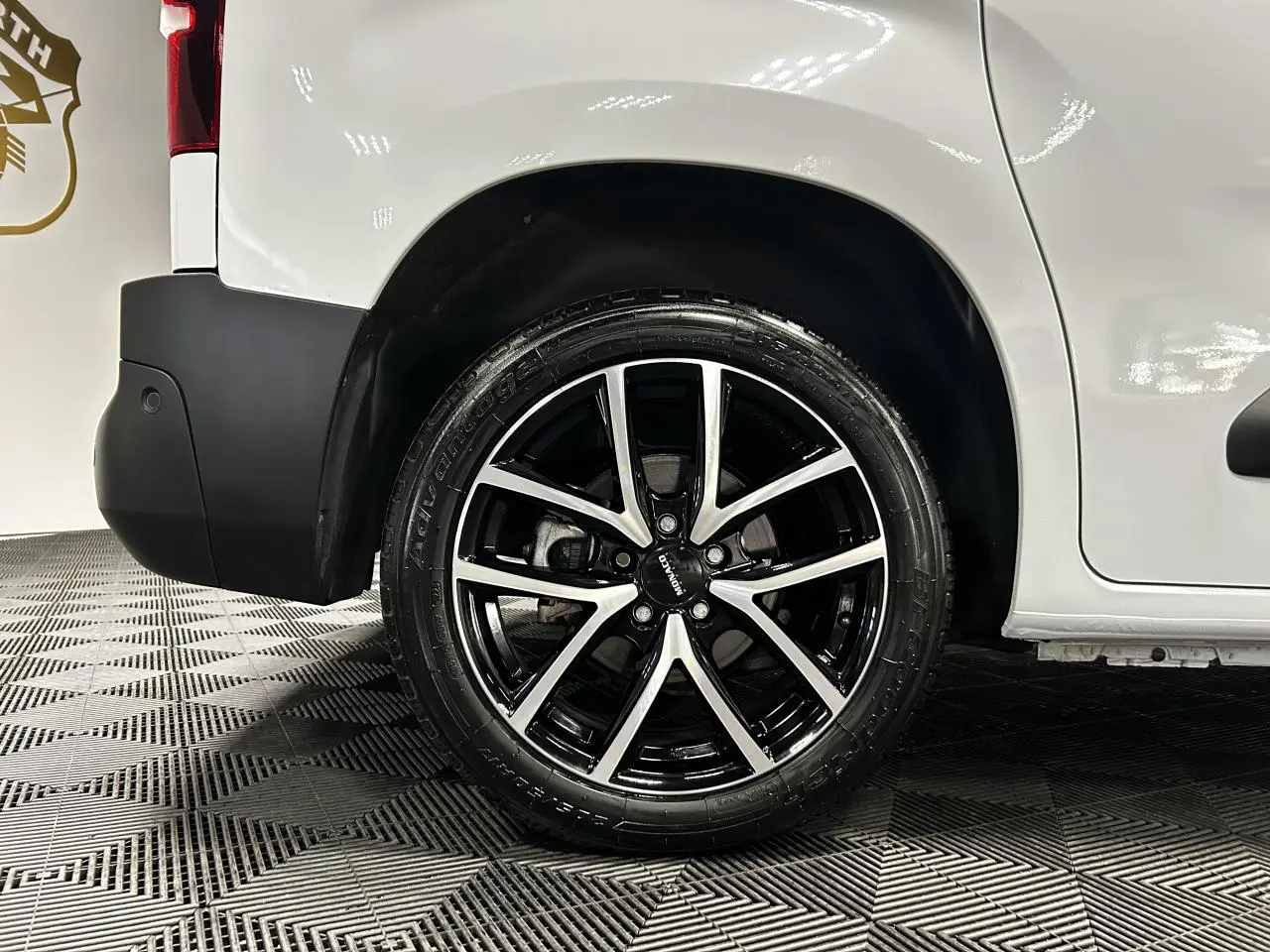 Gros plan sur la roue arrière droite avec jante alu 17 pouces du Peugeot Partner blanc Banquise 2025.