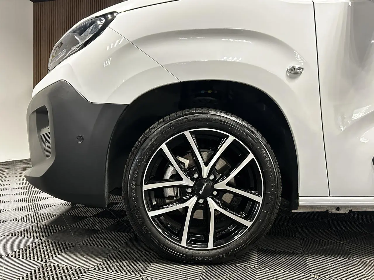 Vue côté avant droit du Peugeot Partner blanc Banquise mettant en valeur la jante alu 17 pouces bicolore.