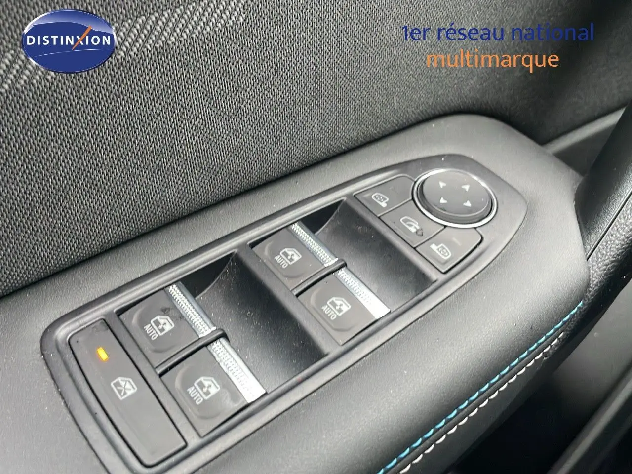 Gros plan sur les commandes des vitres électriques côté gauche de la Renault Symbioz gris Rafale Métal 2025.