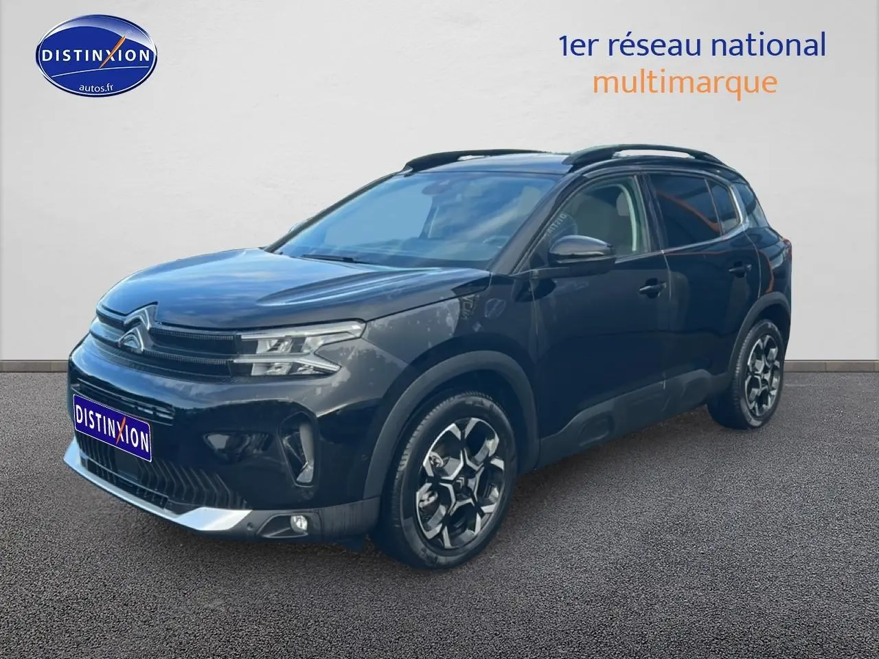 Citroën C5 Aircross noir vue 3/4 avant droit avec jantes alu et barres de toit visibles.