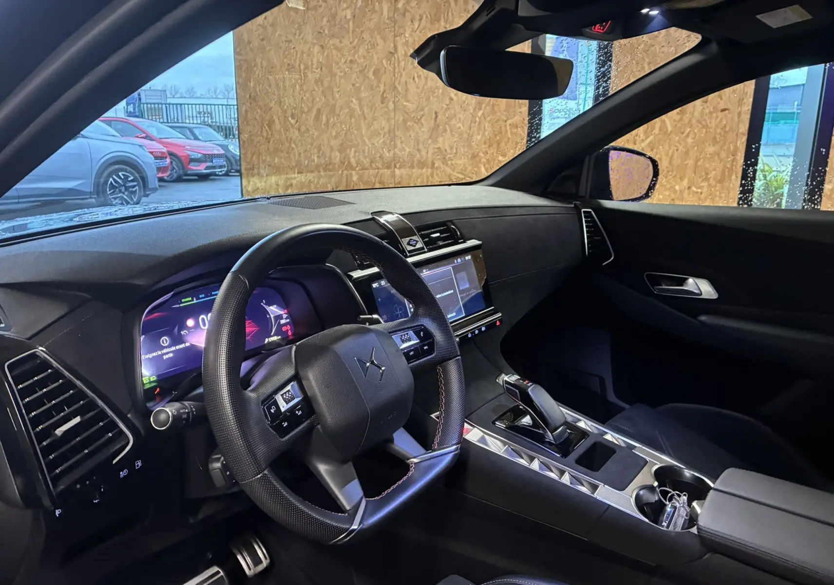 Vue intérieure côté conducteur du DS7 E-TENSE 2024 avec tableau de bord numérique et finitions noires élégantes.