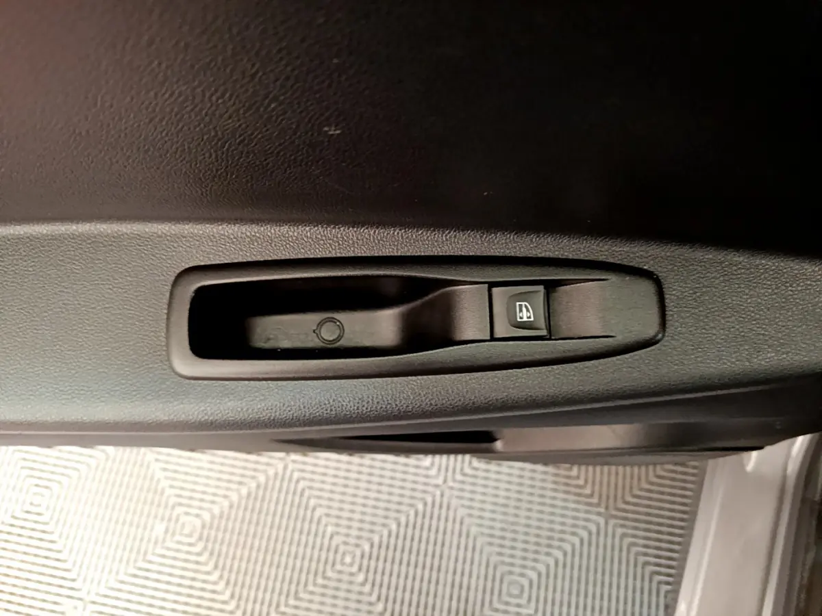 Détail de la commande électrique de lève-vitre sur la porte intérieure d'une Renault Captur gris foncé, version Business.