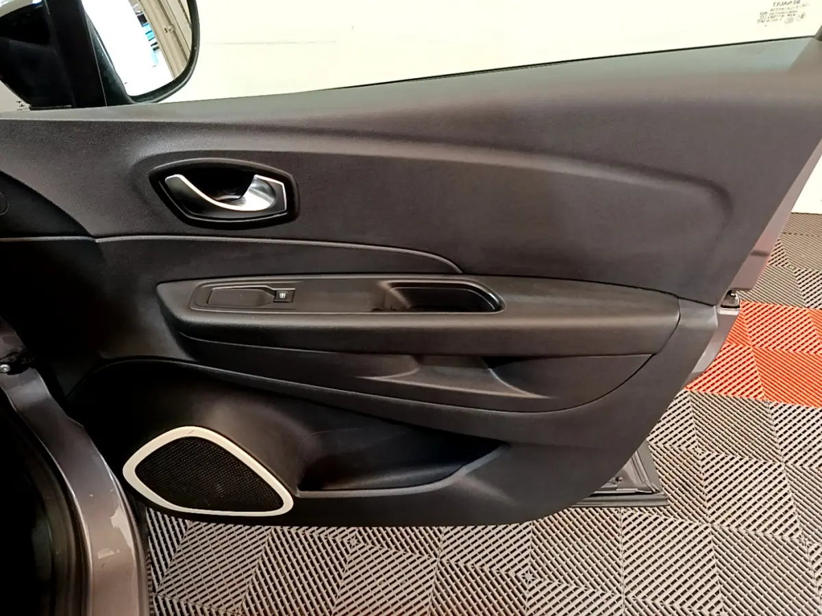 Vue rapprochée de la porte avant gauche gris foncé du Renault Captur 2018, avec poignée intérieure et haut-parleur intégré.