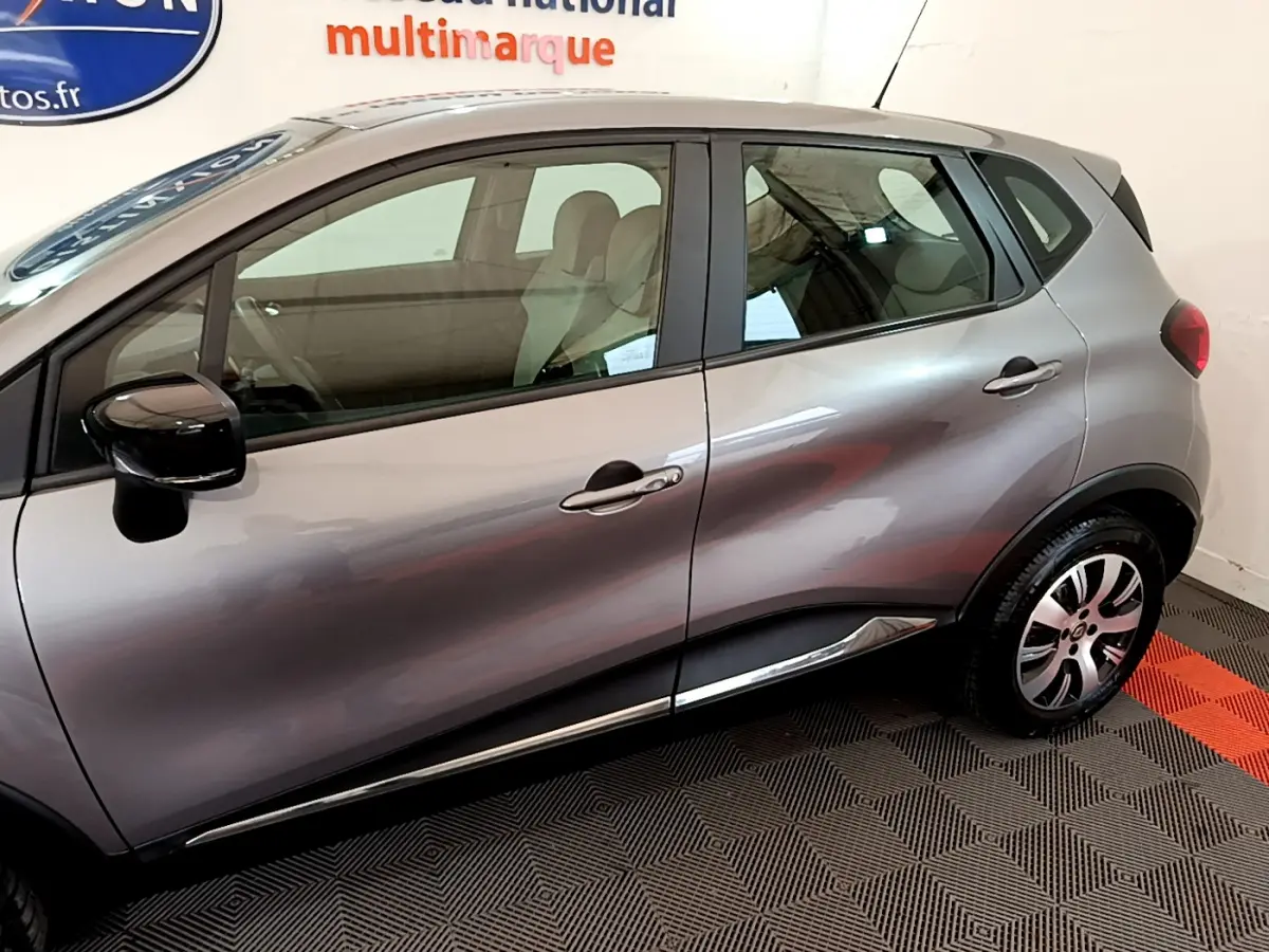 Vue côté droit du Renault Captur gris foncé de 2018, mettant en valeur les portes et la jante alliage.