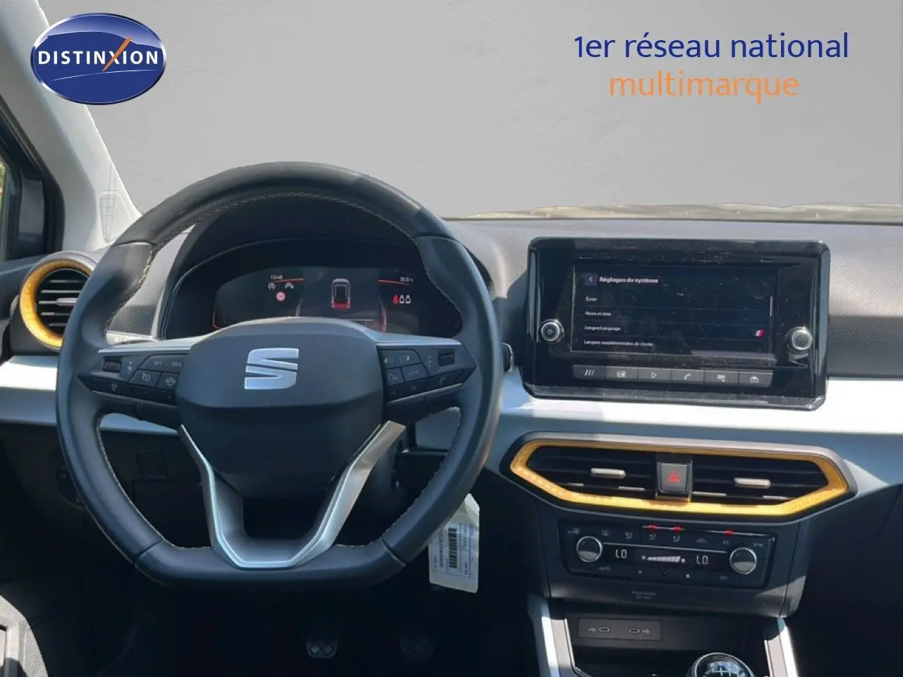 Vue intérieure centrée sur le volant et le tableau de bord du SEAT Arona gris avec détails dorés autour des aérateurs.