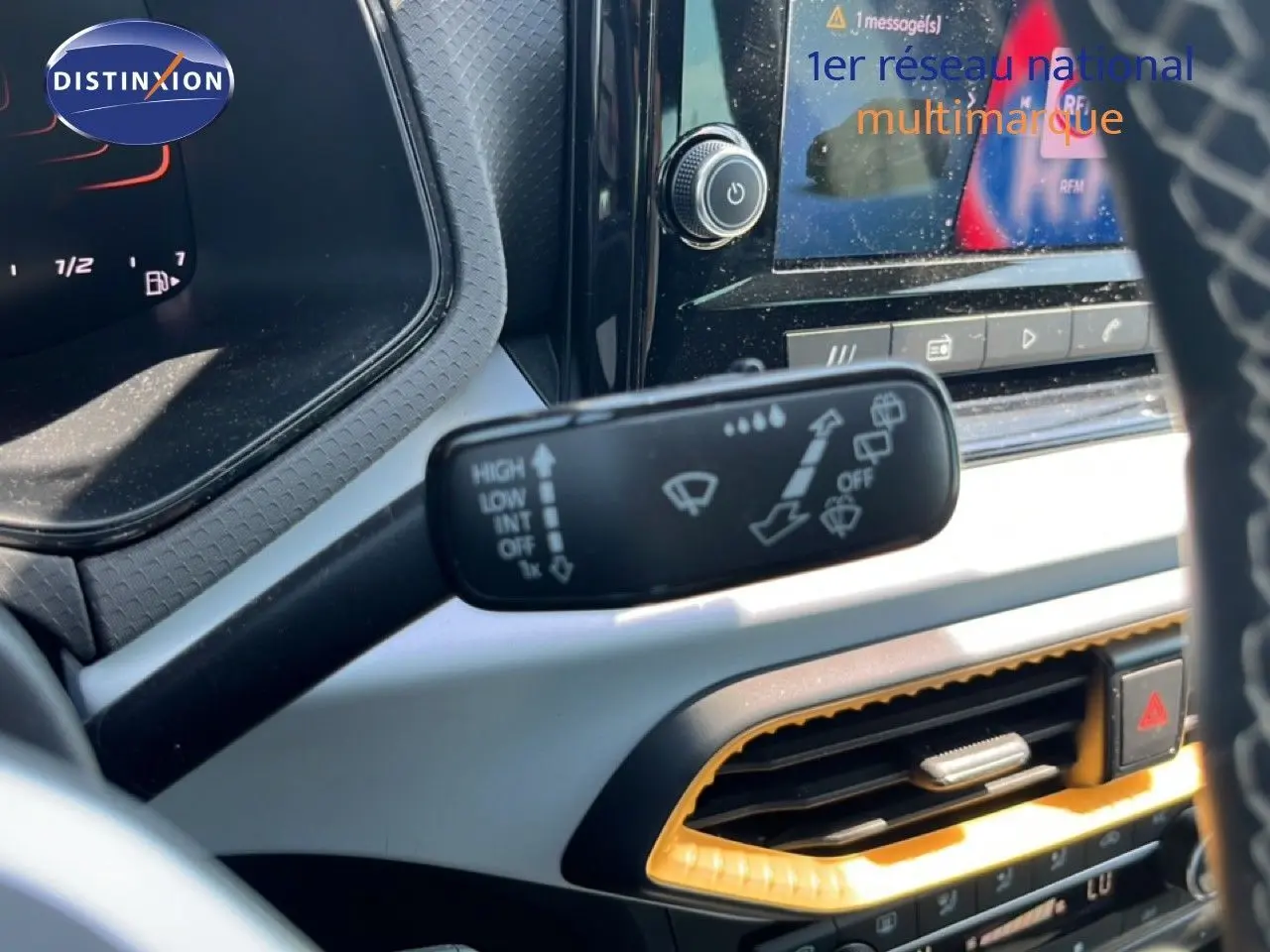 Gros plan intérieur sur la commande d’essuie-glace du SEAT Arona 2025 avec tableau de bord et écran tactile partiellement visibles.