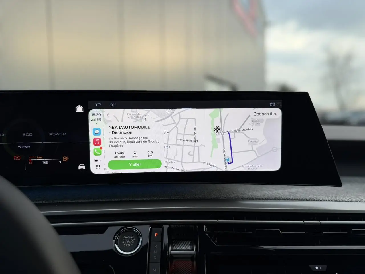 Vue intérieure du tableau de bord du Peugeot 3008 Hybrid 145 Allure 2025 avec écran panoramique incurvé affichant la navigation.