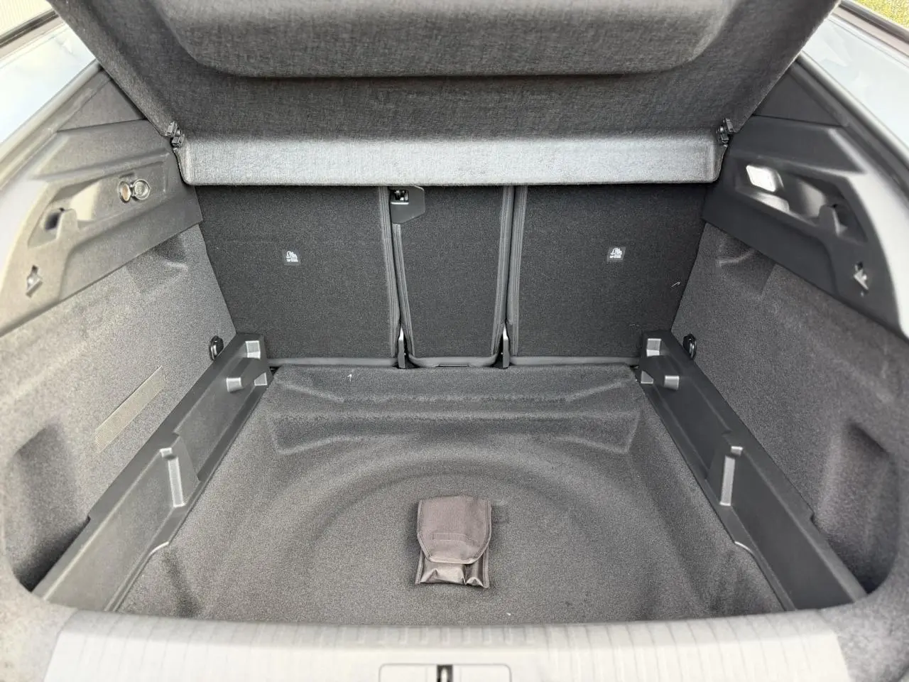 Coffre ouvert en vue plongeante du Peugeot 3008 Hybrid blanc, montrant un espace de rangement vide et propre.