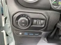 Gros plan sur le tableau de bord gauche de la Jeep Wrangler Unlimited 2023, montrant les commandes d'éclairage et de réglage.