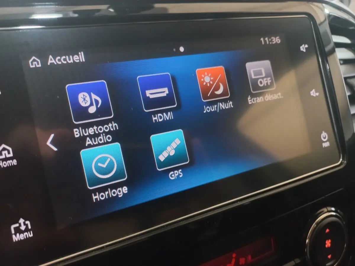 Écran tactile central du Mitsubishi L200 gris foncé, affichant les options Bluetooth, GPS et réglages jour/nuit.