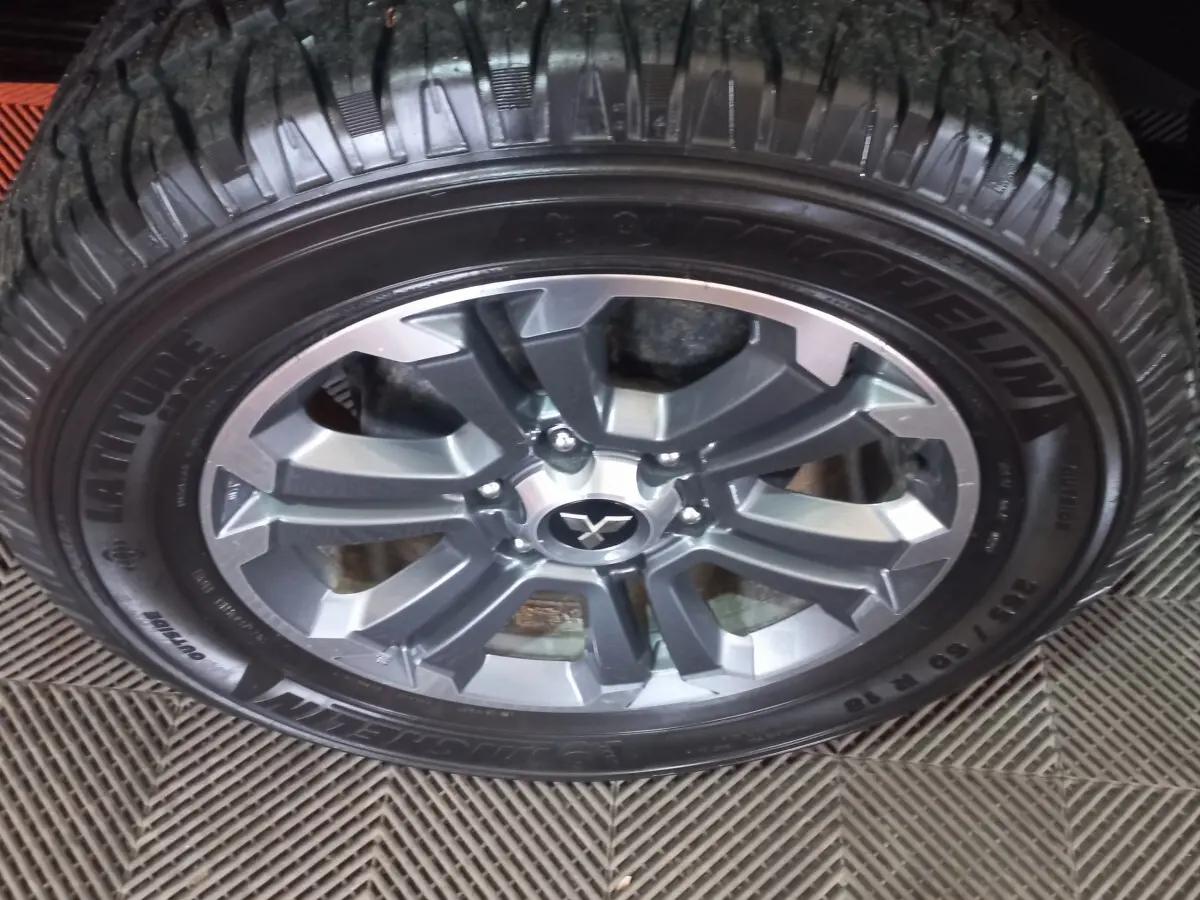 Gros plan sur la roue avant droite du Mitsubishi L200 gris foncé, avec jante alliage et pneu Michelin.
