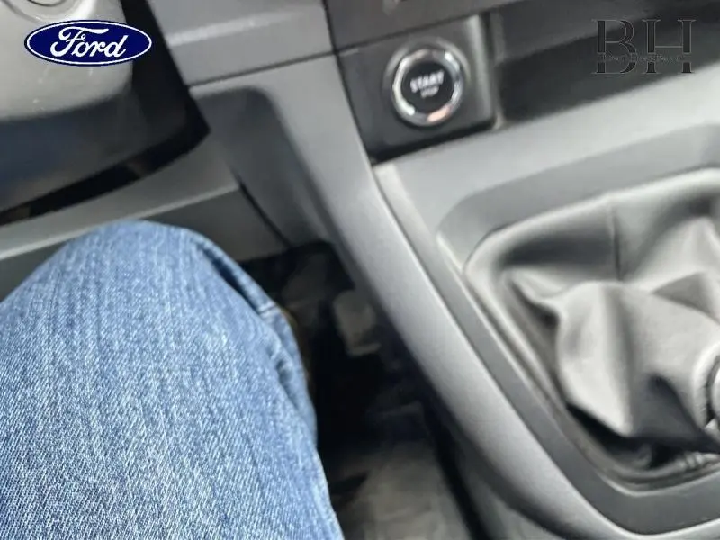 Vue intérieure centrée sur la console centrale et levier de vitesses d'une Citroën Jumpy blanc banquise, avec bouton start visible.