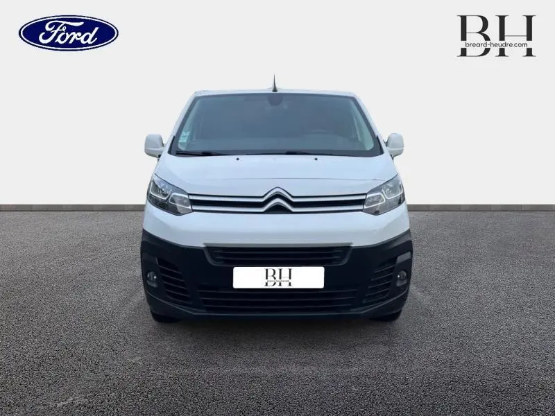 Vue de face du Citroën Jumpy blanc Banquise avec calandre noire et phares halogènes allumés.