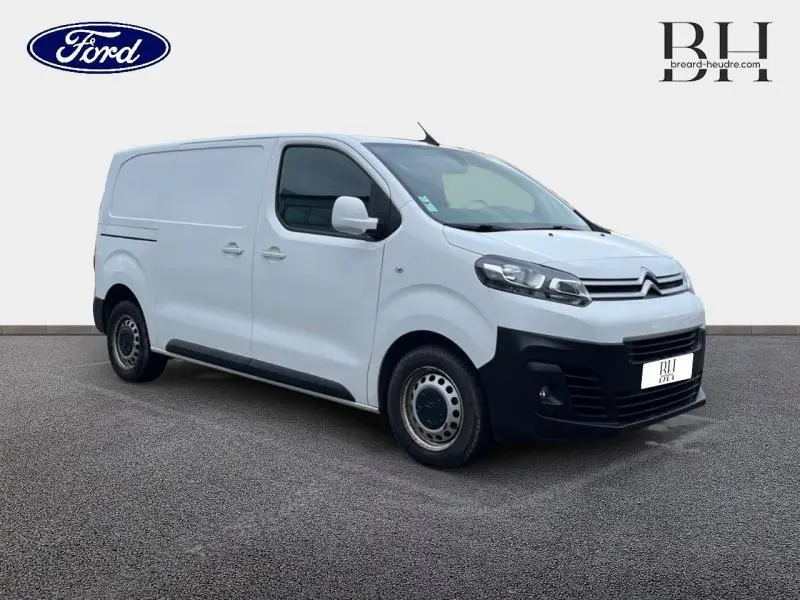 Vue 3/4 avant droit d'un utilitaire Citroën Jumpy blanc Banquise avec pare-chocs noirs et jantes acier.