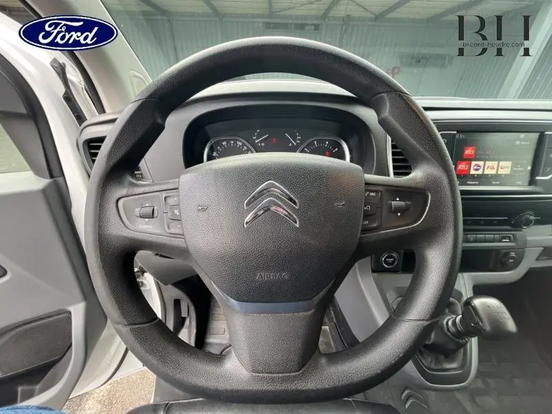 Vue centrée sur le volant noir de Citroën Jumpy blanc Banquise, tableau de bord et écran tactile visibles.