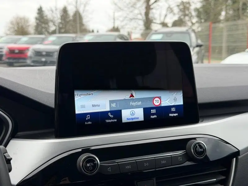 Vue intérieure du tableau de bord du Ford Kuga 2024 avec écran tactile de navigation et commandes audio en noir et argent.