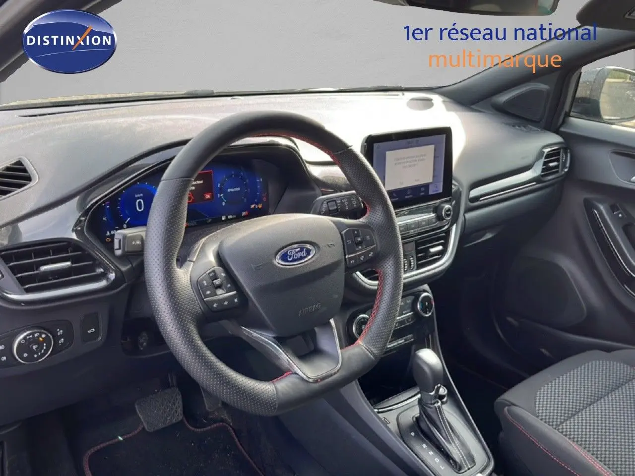 Intérieur de la Ford Puma 2023, vue côté conducteur sur le tableau de bord noir avec volant multifonction et écran tactile central.