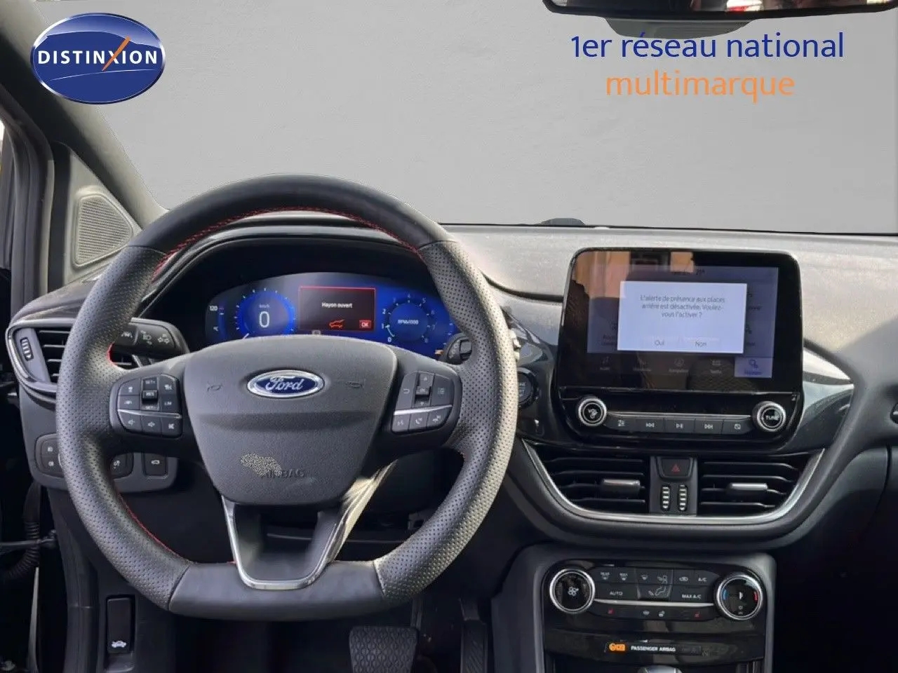 Vue intérieure du tableau de bord et volant du Ford Puma noir agate métal, avec écran tactile central allumé.